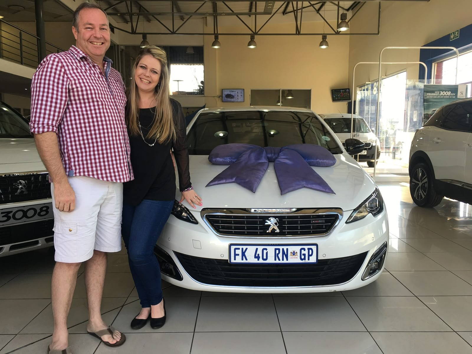 Clients standing beside a white passenger car