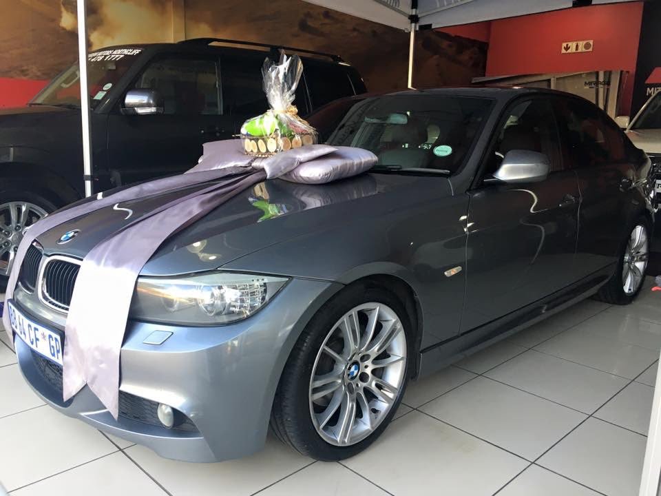 Grey BMW sedan with a showroom bow